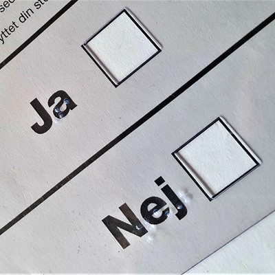 Billede af den følbare plade, der lægges over stemmesedlen med huller til at afkrydse Ja eller Nej 