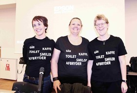 Foto af de tre kursusledere med t-shirts med skrift: GÅR, KAFFE, TOILET, SMILER, AFBRYDER