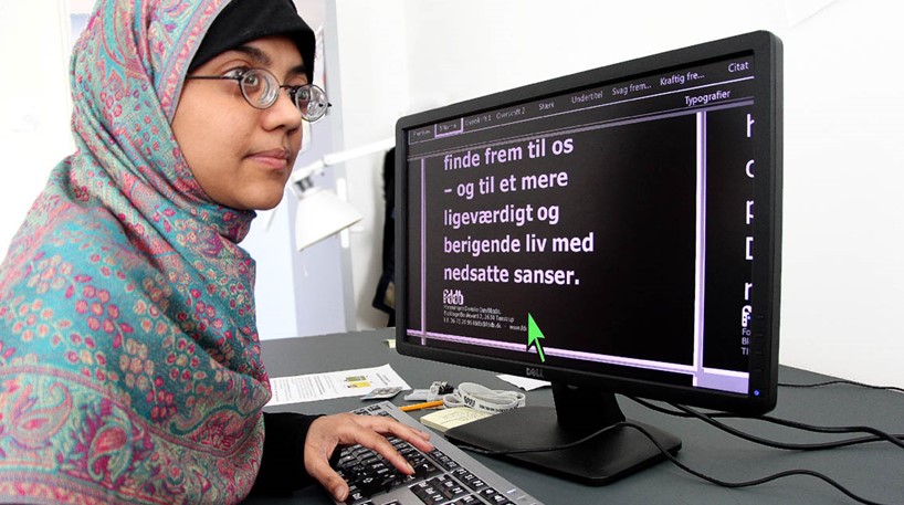 Ung døvblind kvinde arbejder ved PC med stor skrift
