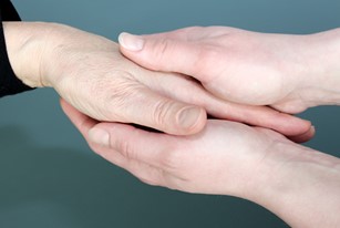 To hænder støtter en ældre hånd